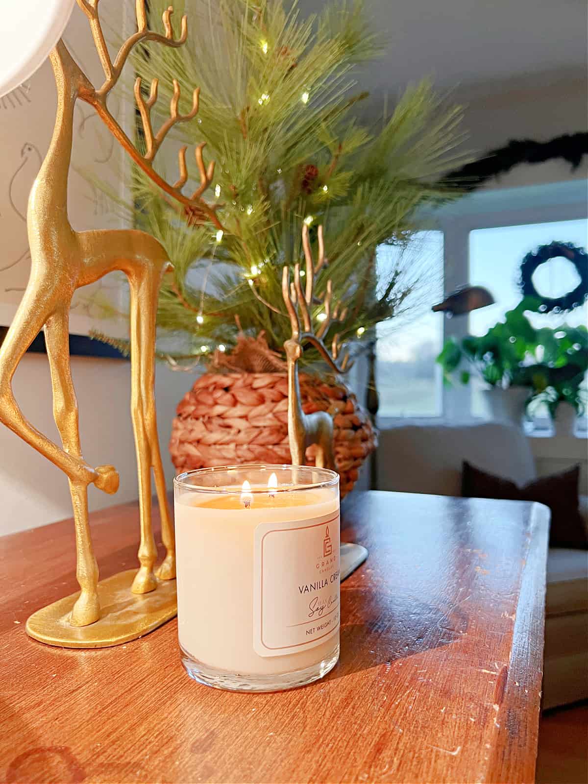 candle and Christmas decor on a dresser