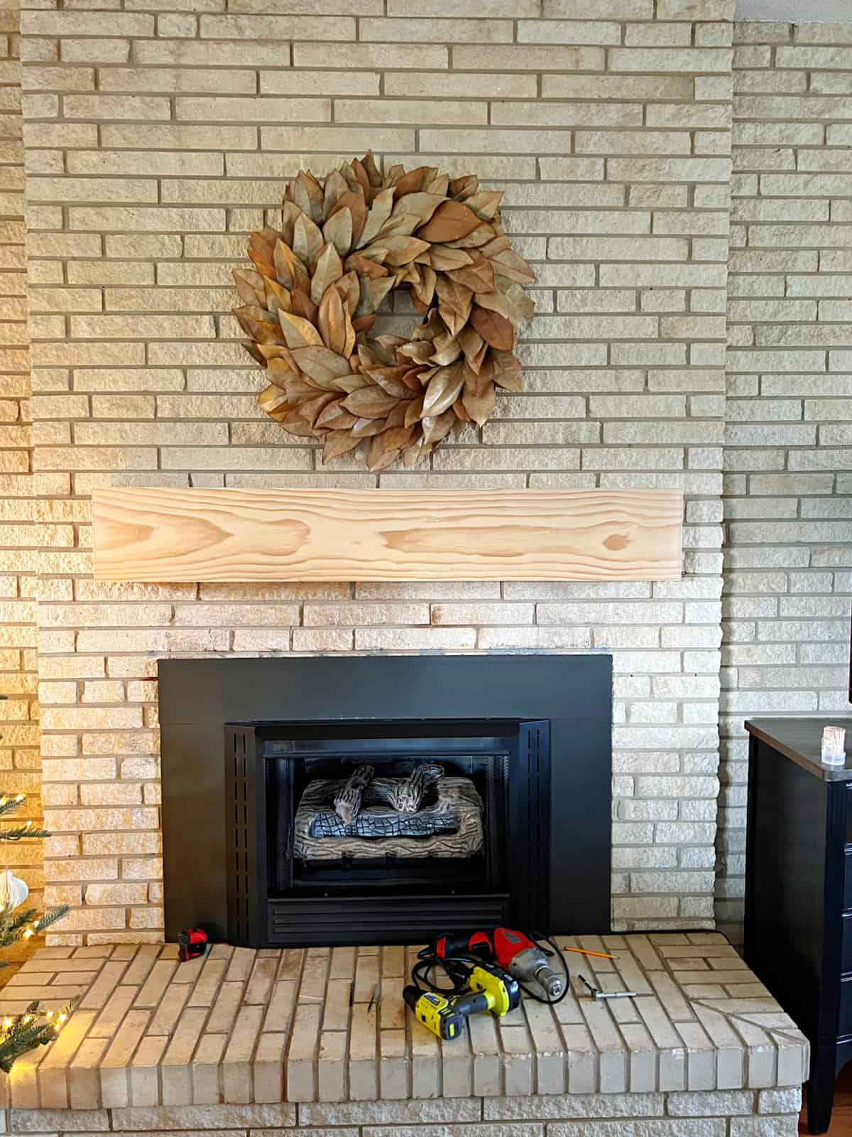 unstained wood mantel shelf hanging on stone fireplace