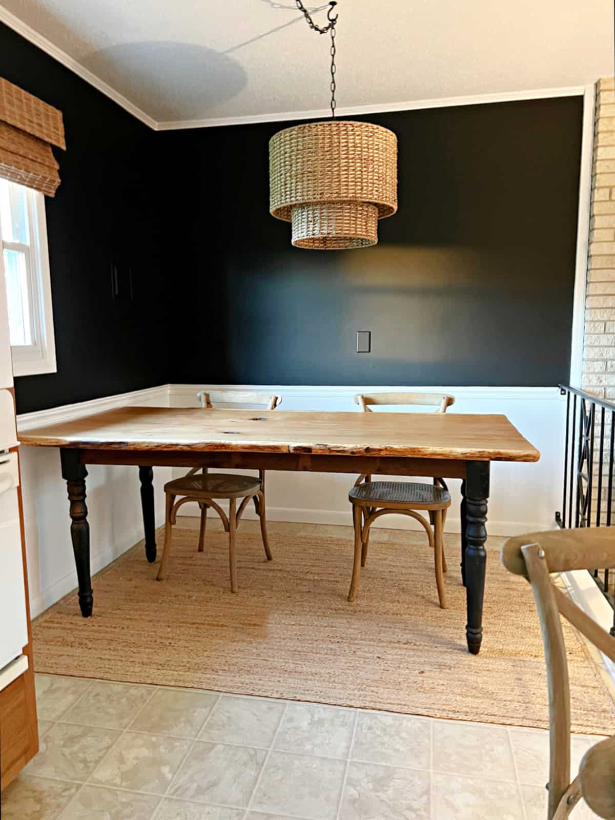 small breakfast nook wth black painted walls and wood top table
