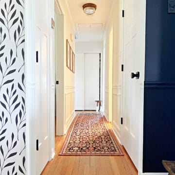 narrow hallway painted white with rug runner