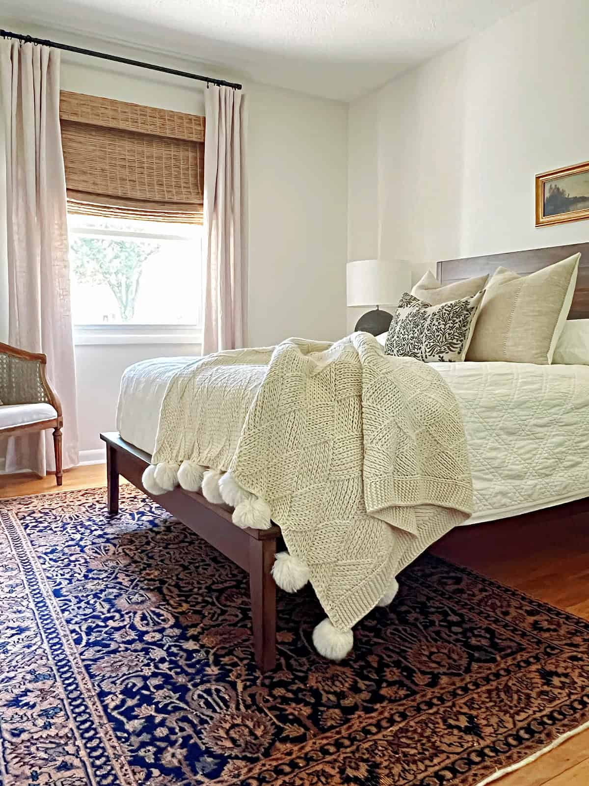 small guest bedroom with bed with throw