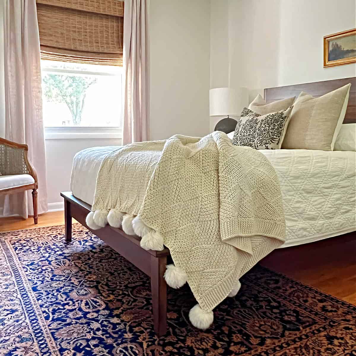 small guest bedroom with bed with throw blanket