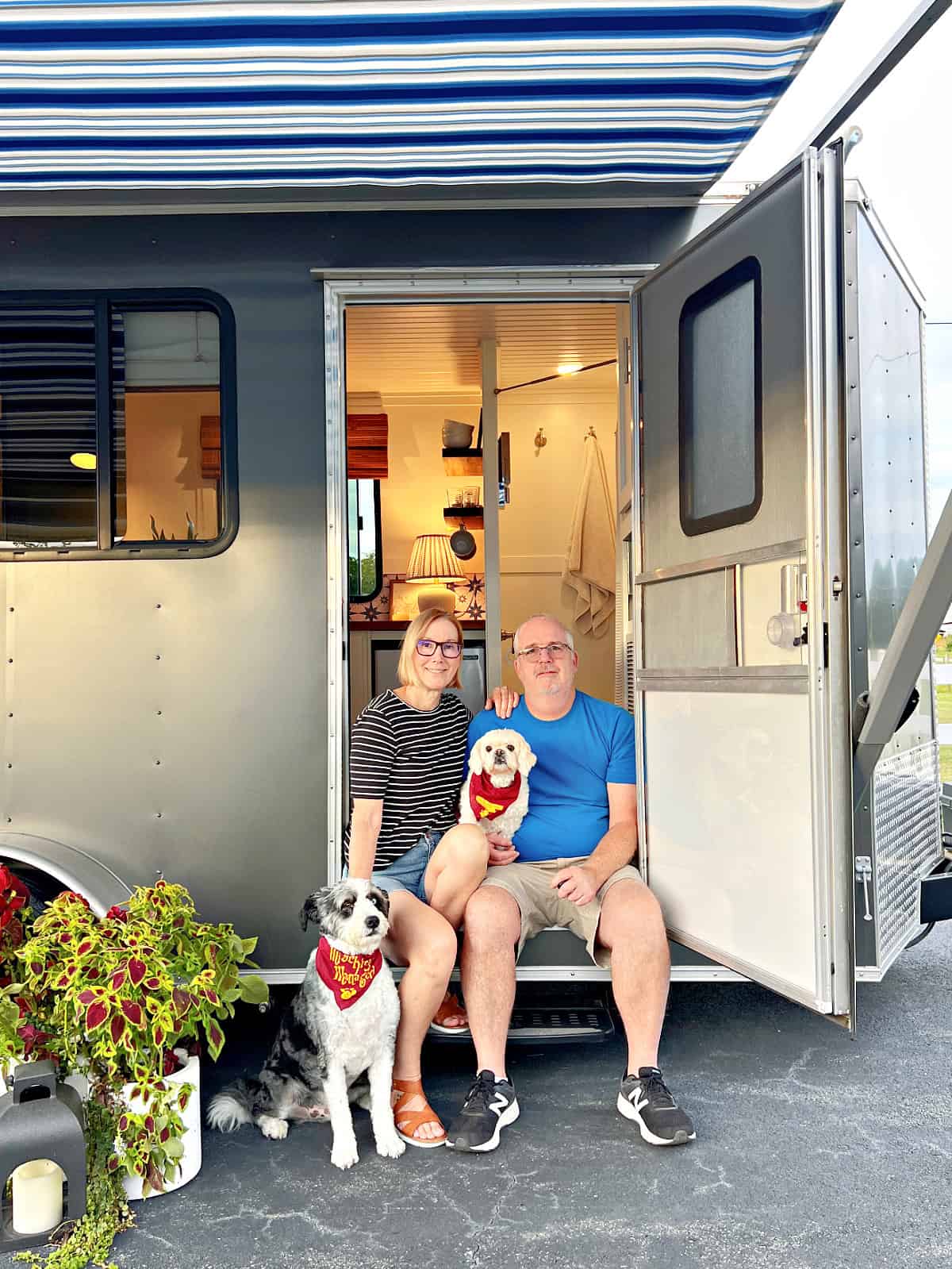 family sitting in doorway of tiny RV