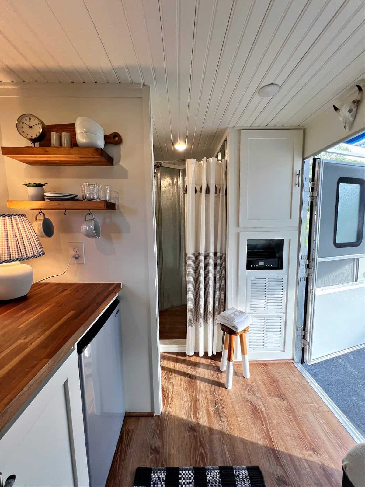 view of kitchen shelves and shower in tiny RV