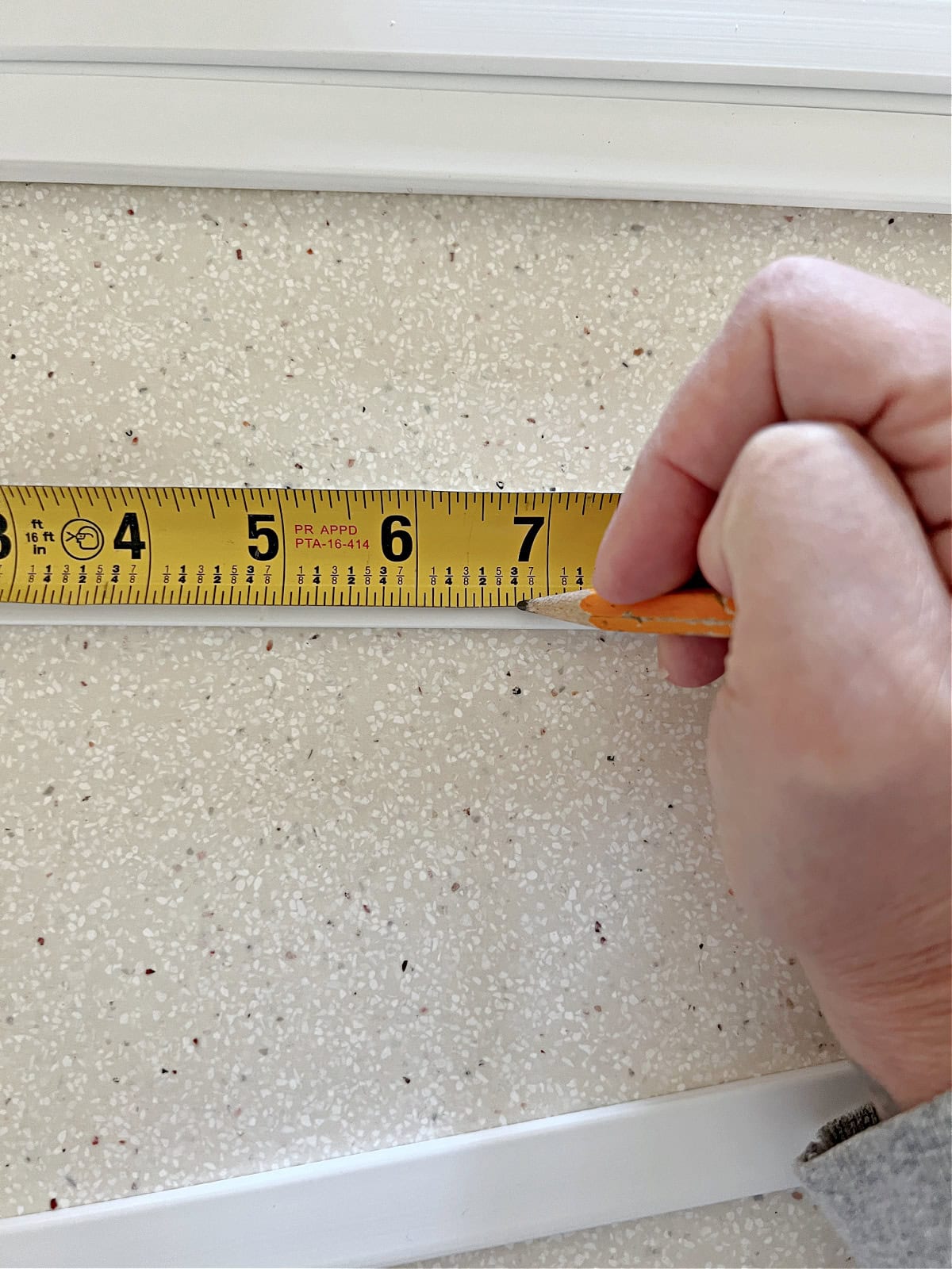 using a measuring tape to mark PVC vinyl strips for window panes
