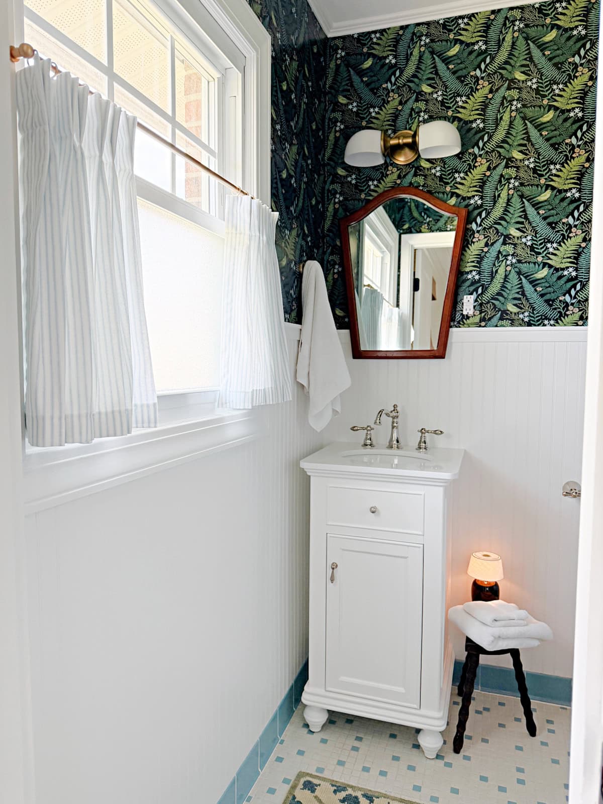 small bathroom with wallpaper and white vanity