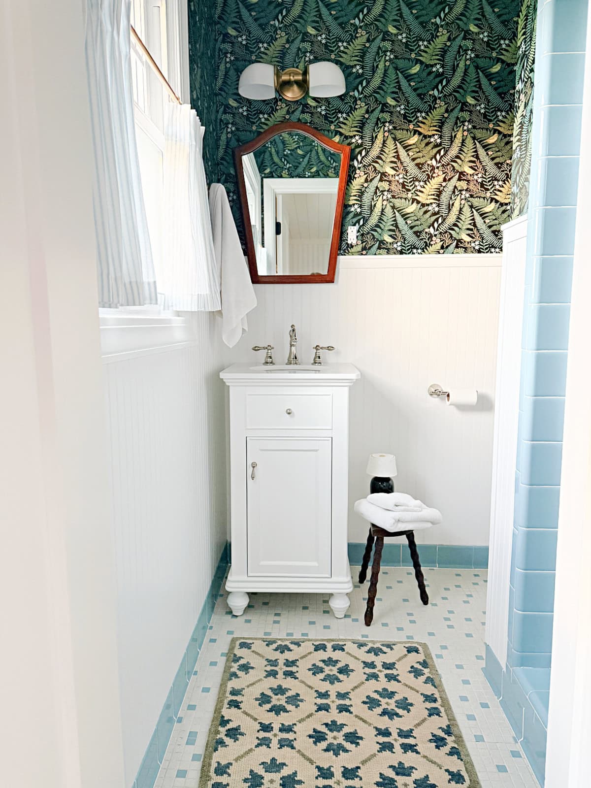 small bathroom with wallpaper and white vanity